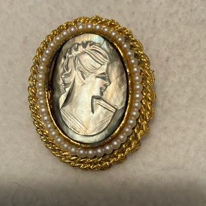 Reflective Silver Face Cameo. Circled by pearls and gold tone casing. Beautiful